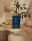Rituals żel do mycia rąk hammam w eleganckiej niebieskiej butelce na łazienkowym blacie z rośliną