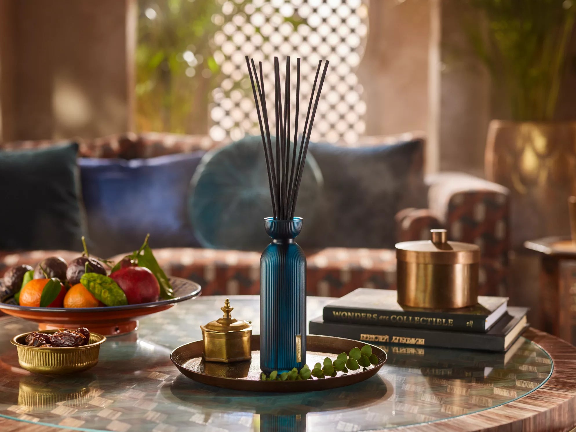 Rituals hammam patyczki zapachowe do firmy w niebieskiej butelce na szklanym stoliku w eleganckim wnętrzu