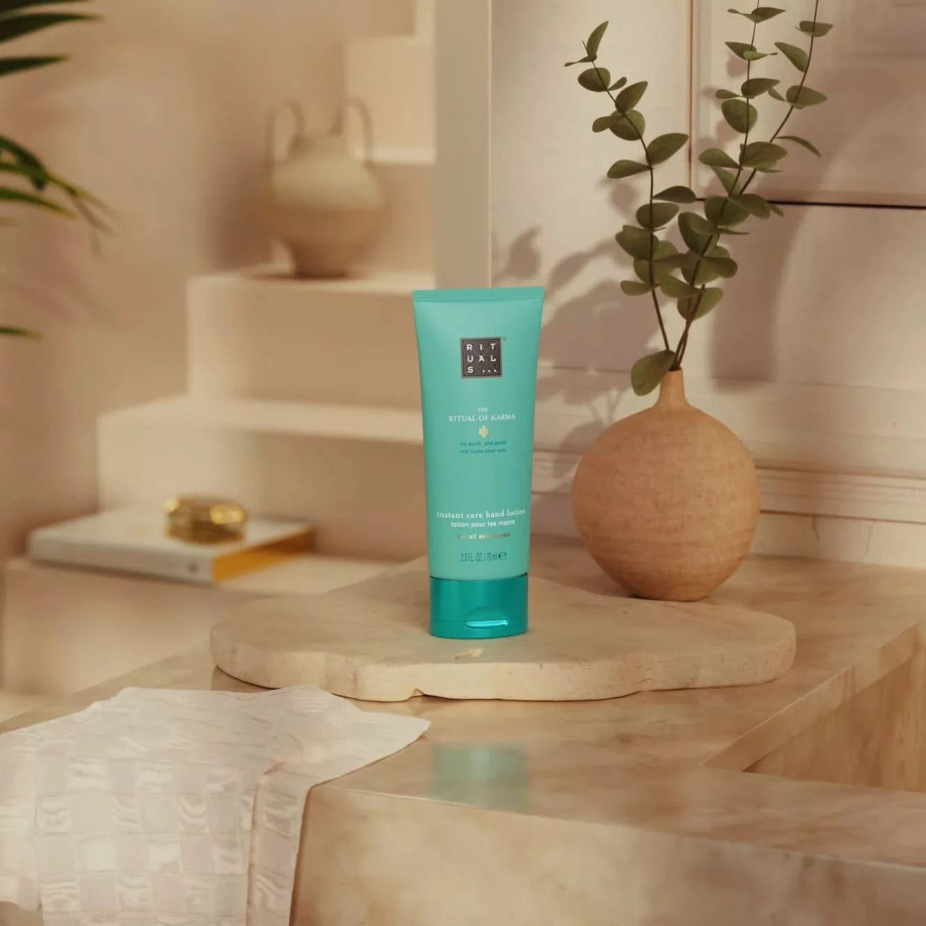 Balsam Rituals w turkusowej tubce na kamiennym blacie w stylowym wnętrzu kosmetyki dla firm rituals