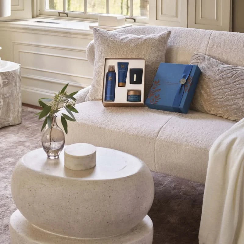 Zestaw podarunkowy kosmetyki Rituals The Ritual of Hammam B2B w eleganckim niebieskim opakowaniu na sofie