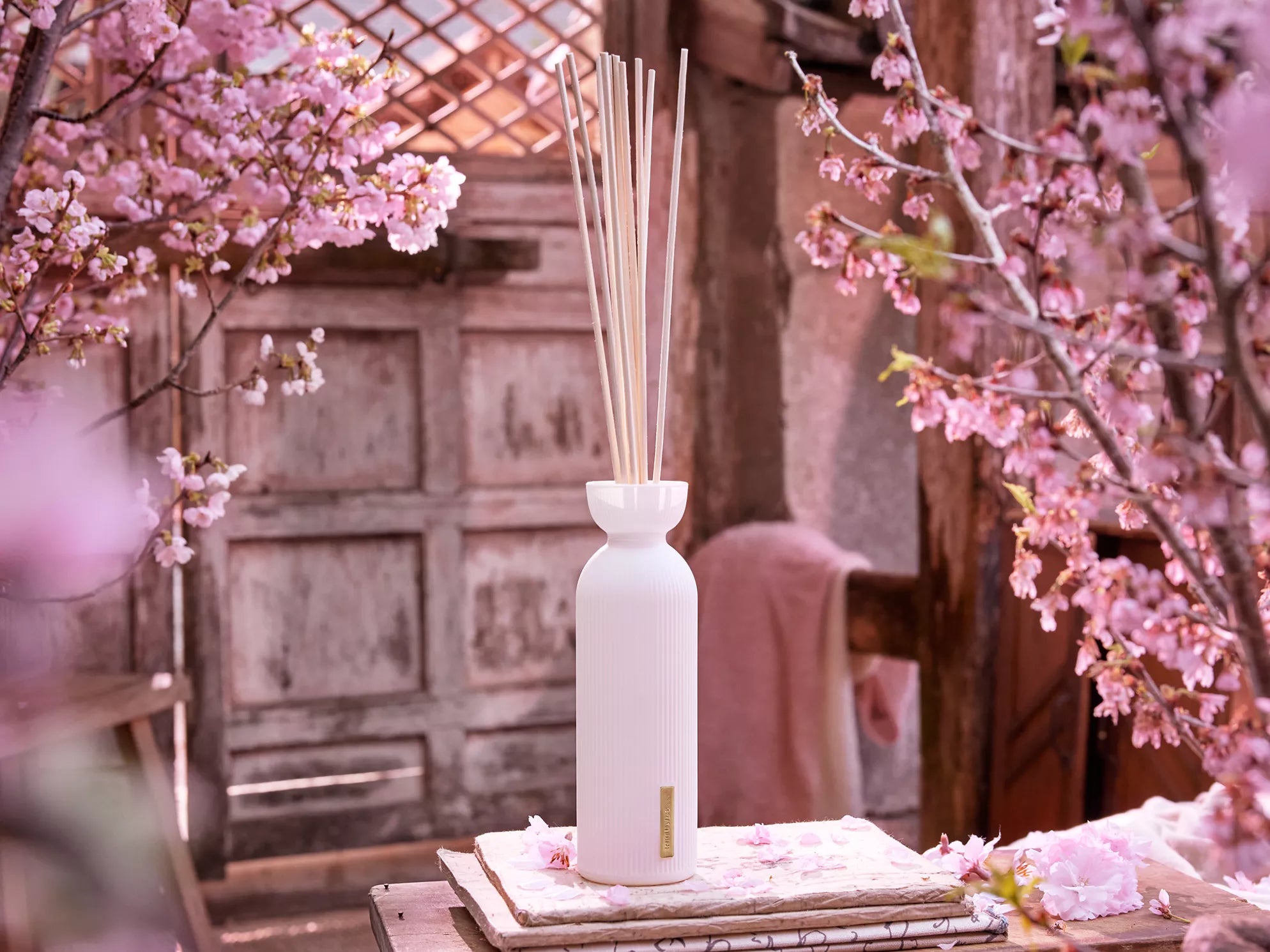 Eleganckie patyczki zapachowe Rituals Sakura w białej butelce ozdobione kwiatami wiśni