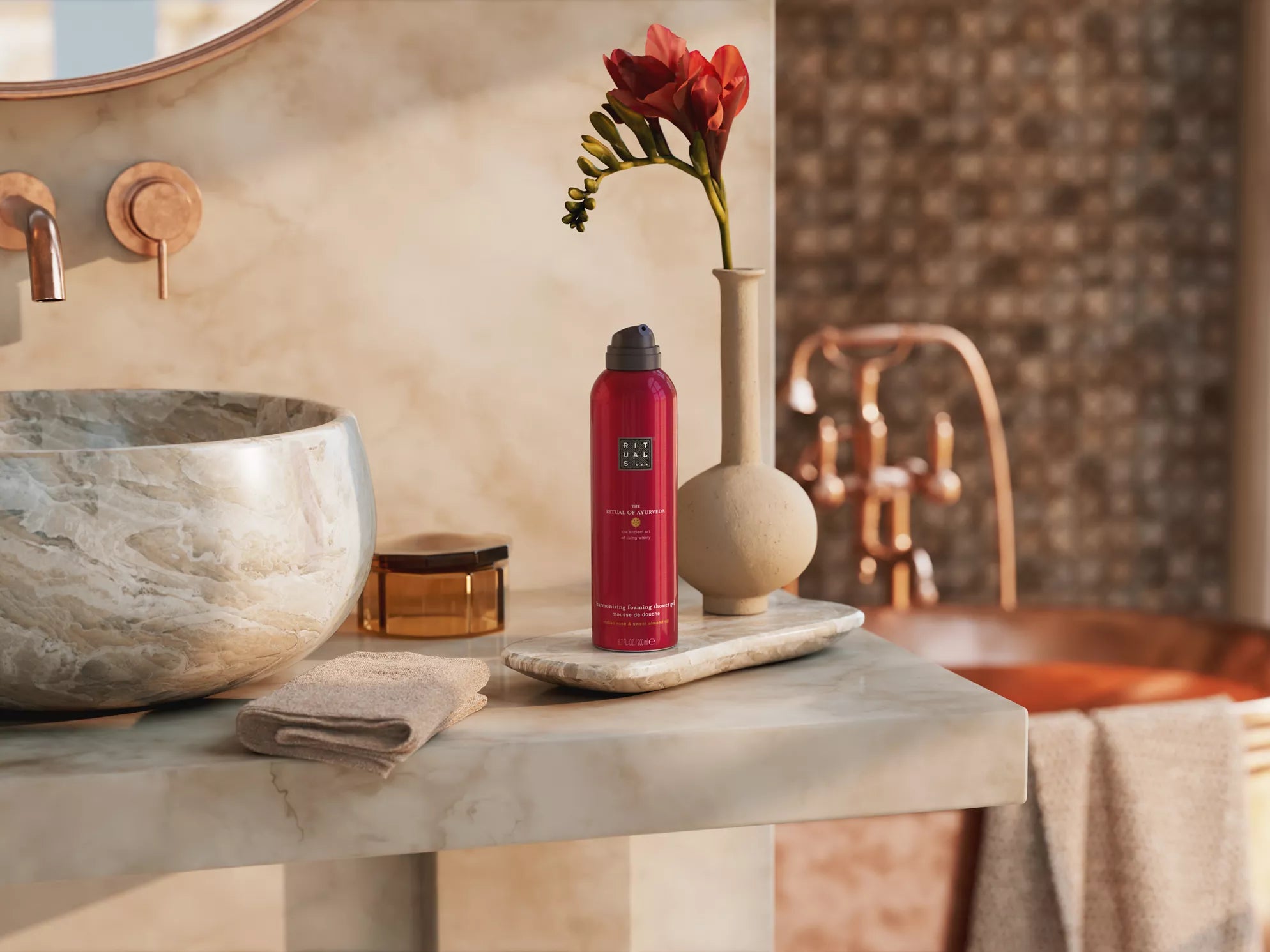 Pianka pod prysznic Rituals z żel pod prysznic z ekstraktami ajurwedyjskimi na marmurowej łazienkowej półce