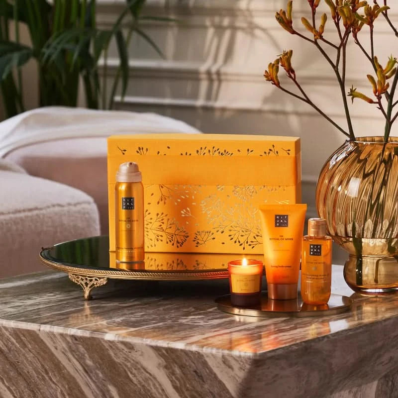 Zestaw prezentowy Rituals Mehr dla firm z kosmetykami i świecą na dekoracyjnym stoliku