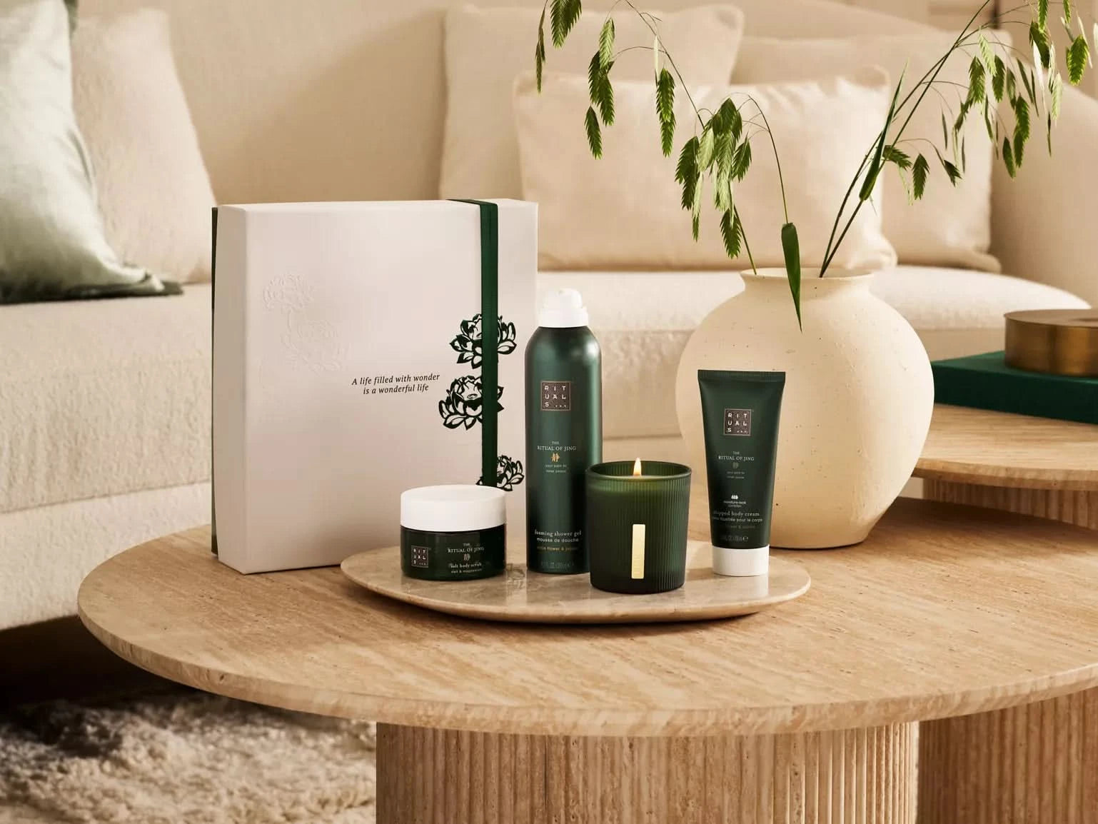 Elegancki zestaw upominkowy Rituals dla firm z kosmetykami na drewnianym stole w salonie