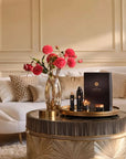 Zestaw upominkowy Rituals Precious Amber na stoliku kawowym z kwiatami w eleganckim salonie