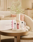 Zestaw upominkowy Rituals Sakura dla firm z kosmetykami na stoliku w eleganckim salonie