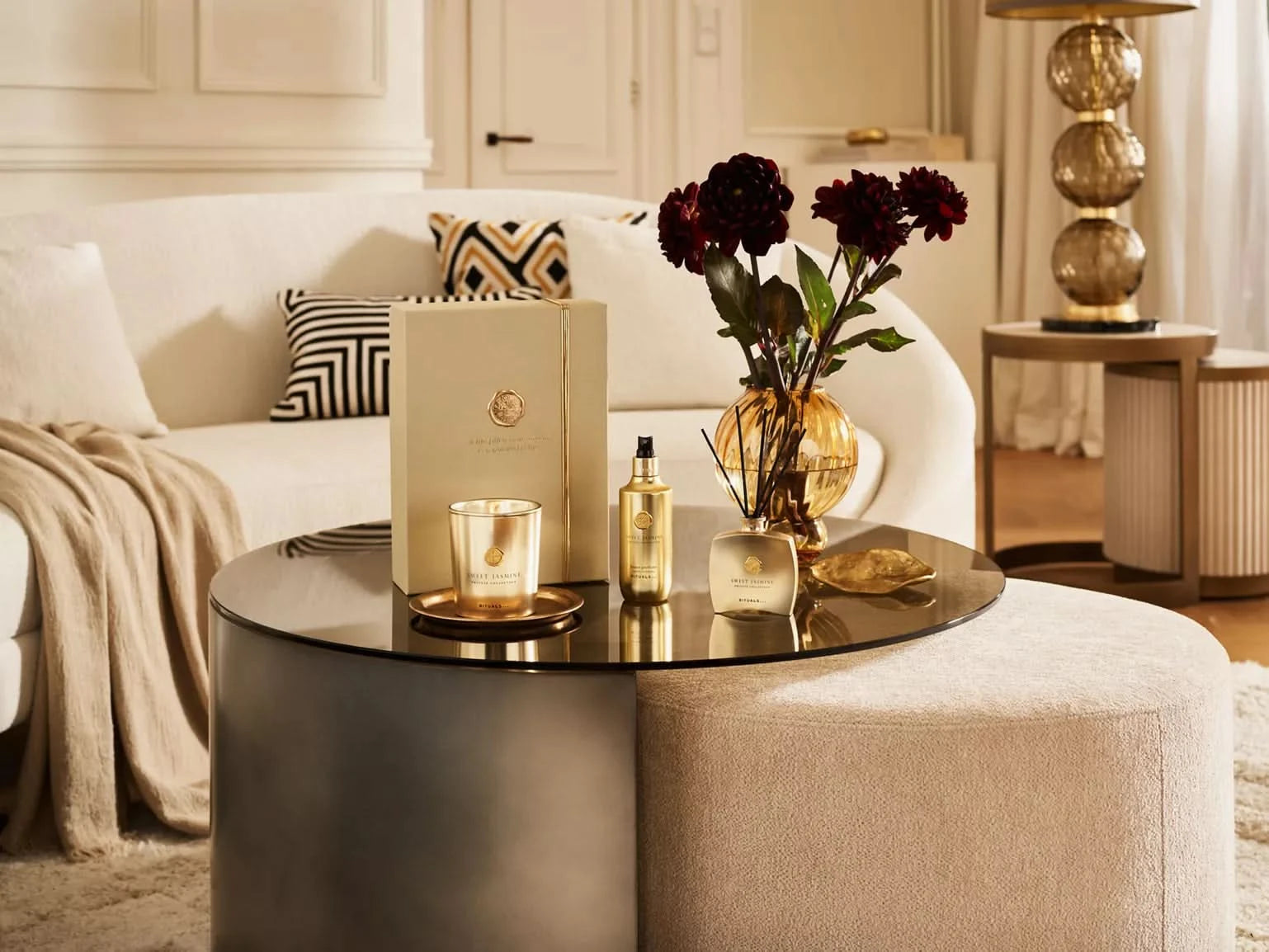 Zestaw upominkowy Rituals Sweet Jasmine na stoliku kawowym z zapachem i świecą w eleganckim salonie