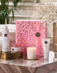 Zestaw prezentowy Rituals Sakura z różowym pudełkiem, świecą i kosmetykami na marmurowym stole