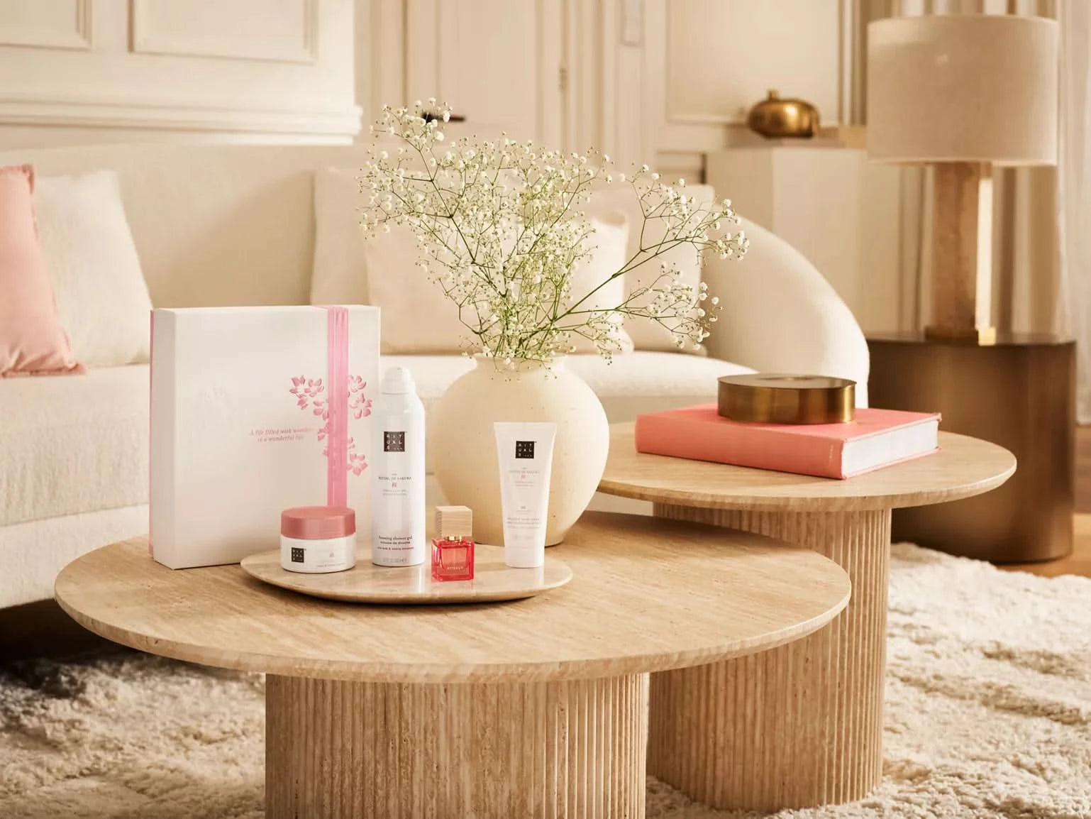 Zestaw upominkowy Rituals Sakura dla firm z kosmetykami na drewnianym stole w przytulnym wnętrzu